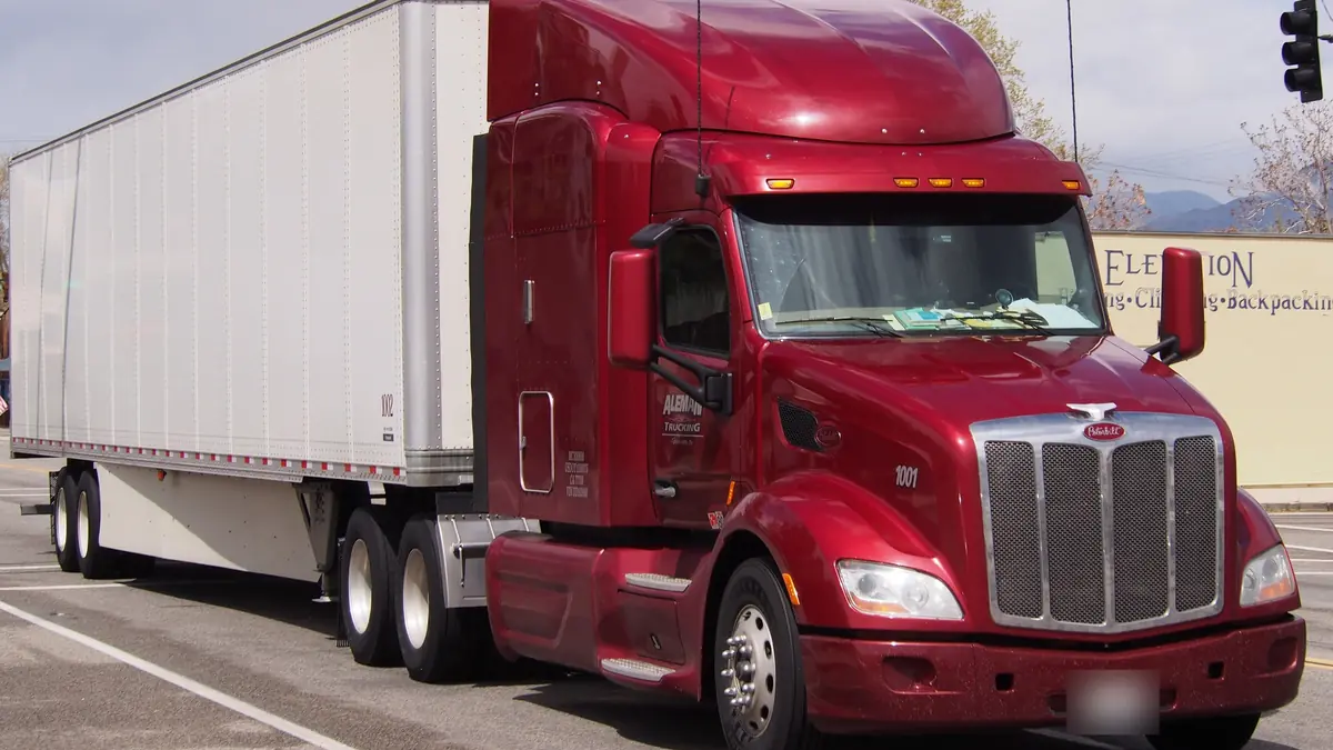 Red Peterbilt 579 with a dry van trailer on a street in Lone Pine, California